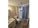 This bathroom includes a shower with blue curtain, newer vanity, and vinyl flooring at 16181 White Hawk Dr, Parker, CO 80134