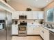 Well-lit kitchen featuring white cabinets, stainless steel appliances, and ample counter space at 16181 White Hawk Dr, Parker, CO 80134