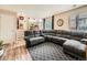 Open-concept living room boasts wood floors, neutral paint, and a large, comfortable sectional sofa at 16181 White Hawk Dr, Parker, CO 80134