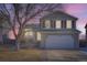 Two-story house with attached garage, illuminated at dusk, showcasing its architectural details at 16641 Martingale Dr, Parker, CO 80134