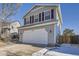 Two-story house with attached garage and light beige siding, viewed from the driveway at 16641 Martingale Dr, Parker, CO 80134
