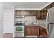 A kitchen featuring stainless steel appliances, dark wood cabinets, granite counters, and decorative backsplash at 8826 E Florida Ave # G11, Denver, CO 80247