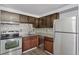 Modern kitchen with stainless steel appliances, wood cabinets, mosaic backsplash, and granite countertops at 8826 E Florida Ave # G11, Denver, CO 80247