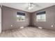 Bedroom featuring two windows, ceiling fan and wood-look flooring at 710 4Th St, Bennett, CO 80102