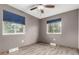 Charming bedroom featuring modern ceiling fan, two windows, and beautiful hardwood floors at 710 4Th St, Bennett, CO 80102