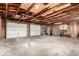 Spacious three-car garage featuring exposed wood beam ceiling and ample storage space at 710 4Th St, Bennett, CO 80102