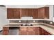 Kitchen featuring stainless steel appliances, wooden cabinetry, and tile backsplash at 710 4Th St, Bennett, CO 80102
