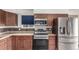 Bright kitchen featuring stainless steel appliances, wooden cabinets, and a tiled backsplash at 710 4Th St, Bennett, CO 80102
