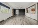 Open-concept living room with wood-look floors, ceiling fan, and modern black accent wall at 710 4Th St, Bennett, CO 80102