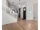 Bright entryway showcasing hardwood floors, white staircase, and stylish black doors for a modern appeal at 772 Ivywood Ct, Highlands Ranch, CO 80126