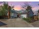 Charming single-story home featuring a brick chimney and a two-car garage against a sunset sky at 772 Ivywood Ct, Highlands Ranch, CO 80126