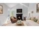 Cozy living room features a fireplace with black tile surround, plush furniture, and light wood flooring at 772 Ivywood Ct, Highlands Ranch, CO 80126