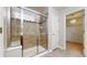 Bathroom featuring tiled walk-in shower and access to walk-in closet at 13684 Lilac St, Thornton, CO 80602