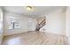 Inviting living room showcasing wood-look flooring, natural light, and easy access to the entry and staircase at 13684 Lilac St, Thornton, CO 80602
