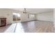 Spacious open-concept living area with hardwood floors leading to a sliding glass door, windows and modern lighting at 13684 Lilac St, Thornton, CO 80602