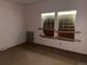 Empty bedroom with plywood covered windows and neutral walls at 5500 Dacono Ct, Byers, CO 80103