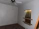 Bedroom showing an open ceiling fan and natural light from a boarded window at 5500 Dacono Ct, Byers, CO 80103