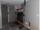 A room in need of renovation, featuring tile walls, bare drywall, and exposed wiring at 5500 Dacono Ct, Byers, CO 80103