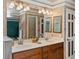 Bathroom featuring double sink vanity, granite countertops, and large well lit mirror at 10954 W 100Th Way, Broomfield, CO 80021