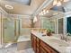 Bathroom with double sink vanity, shower with gold trim, and skylight at 10954 W 100Th Way, Broomfield, CO 80021