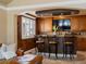 Elegant kitchen bar with granite countertops, wooden cabinetry, and a mounted TV at 10954 W 100Th Way, Broomfield, CO 80021