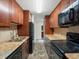 Efficient galley kitchen featuring sleek black appliances and granite countertops with a tiled backsplash at 10954 W 100Th Way, Broomfield, CO 80021