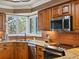 Close up of the kitchen showcasing granite countertops, stainless steel appliances, and a copper backsplash at 10954 W 100Th Way, Broomfield, CO 80021