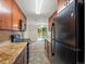 Galley kitchen with warm cabinets and stone counters, with access to the outdoor living area at 10954 W 100Th Way, Broomfield, CO 80021