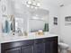 Bathroom featuring a modern vanity with a large mirror and contemporary lighting fixtures at 17616 Bluetrail Ave, Parker, CO 80134