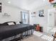 Neutral bedroom with a black bedspread, shelves on the wall, and a window at 17616 Bluetrail Ave, Parker, CO 80134