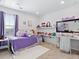 Bright bedroom featuring a plush purple bedspread, white walls, and a dedicated desk area at 17616 Bluetrail Ave, Parker, CO 80134