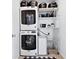 Functional laundry room with stacked washer and dryer and built-in shelving at 17616 Bluetrail Ave, Parker, CO 80134