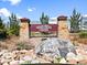 Elegant neighborhood sign featuring natural stone pillars and wrought iron accents at 17616 Bluetrail Ave, Parker, CO 80134