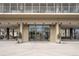 Modern building entrance featuring glass doors, brick accents, and decorative planters at 1201 N Williams St # 16A, Denver, CO 80218