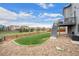 Landscaped backyard features a stone patio, a grassy area, and a wooden fence for privacy, perfect for outdoor enjoyment at 7154 E 131St Pl, Thornton, CO 80602