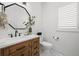 Modern bathroom with wood vanity, stone counter, and decorative mirror at 7154 E 131St Pl, Thornton, CO 80602