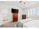 Bright bedroom features a mounted television, wood furniture, and white plantation shutters for ample natural light at 7154 E 131St Pl, Thornton, CO 80602
