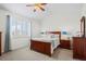 Comfortable bedroom with a wooden bed frame, side tables, and window with natural light shining through at 7154 E 131St Pl, Thornton, CO 80602