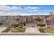 Aerial view of a two-story home with a three-car garage, stone accents, landscaping, and neighborhood view at 7154 E 131St Pl, Thornton, CO 80602