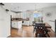 Eat-in kitchen and dining space featuring white cabinetry, modern appliances, a dining area, and hardwood flooring at 7154 E 131St Pl, Thornton, CO 80602