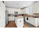 Modern white kitchen with stainless steel appliances, hardwood floors, granite countertops, and an island at 7154 E 131St Pl, Thornton, CO 80602