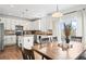 Open floor plan with eat in kitchen featuring modern stainless appliances, tile backsplash and hardwood floors at 7154 E 131St Pl, Thornton, CO 80602