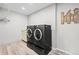 Well-equipped laundry room featuring a modern, dark-colored washer and dryer set with beautiful flooring at 7154 E 131St Pl, Thornton, CO 80602