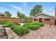 View of a serene backyard with manicured garden beds, brick paver patio, wooden fence, and brick building at 3611 N Vine St, Denver, CO 80205