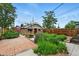 Charming backyard with lush garden beds, brick paver patio, wooden fence, and a brick detached building at 3611 N Vine St, Denver, CO 80205