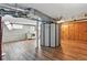 Open basement area featuring wood-look flooring, privacy screen, exposed ductwork, and a laundry area with a white washer and dryer at 3611 N Vine St, Denver, CO 80205