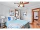 Cozy bedroom with wood floors, ceiling fan, updated trim, and a blue bedspread at 3611 N Vine St, Denver, CO 80205