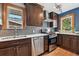 Well-lit kitchen featuring stainless steel appliances, dark cabinets, and hardwood floors at 3611 N Vine St, Denver, CO 80205