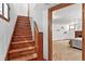 Wooden staircase leading to a cozy basement room with carpet and a brick fireplace at 3611 N Vine St, Denver, CO 80205