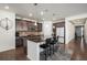 Modern kitchen features a central island with seating, stainless appliances, and warm brown cabinetry at 2906 E 163Rd Ave, Thornton, CO 80602